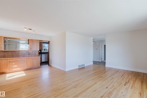 Hardwood-finish flooring throughout, featuring a built-in wood cabinetry unit with glass display cases - 3752 114 Street, Edmonton, AB - Indoor