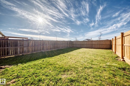 Expansive backyard featuring a manicured lawn, full perimeter wood fencing, and a level grade - 1669 Hammond Crescent Nw, Edmonton, AB - Outdoor
