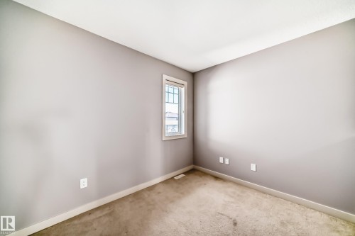 Neutral-toned room with carpet flooring, a single double-hung window with white trim, and light gray walls - 1669 Hammond Crescent Nw, Edmonton, AB - Indoor Photo Showing Other Room