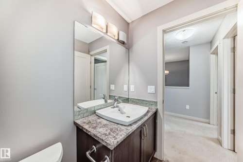Bathroom vanity with a vessel sink, a granite-finish countertop, and a tiled backsplash - 1669 Hammond Crescent Nw, Edmonton, AB - Indoor Photo Showing Bathroom