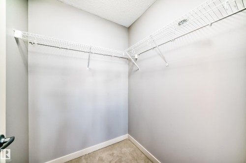 Closet space featuring L-shaped wire shelving, light gray walls, white baseboards, and neutral-toned flooring - 1669 Hammond Crescent Nw, Edmonton, AB - Indoor With Storage