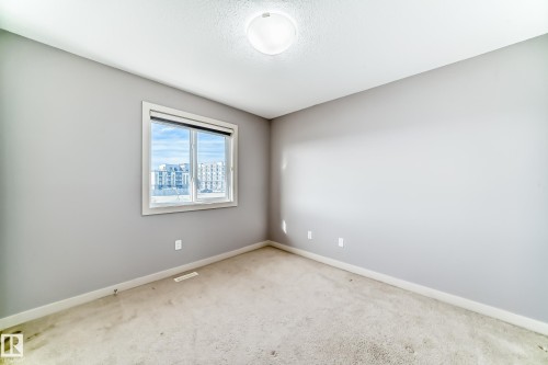 Neutral-toned room featuring a single window with white trim, light gray walls, and textured carpeting - 1669 Hammond Crescent Nw, Edmonton, AB - Indoor Photo Showing Other Room