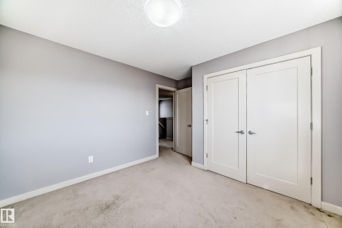 Carpeted interior room featuring light gray walls, white trim, and a flush mount ceiling light fixture - 1669 Hammond Crescent Nw, Edmonton, AB - Indoor Photo Showing Other Room