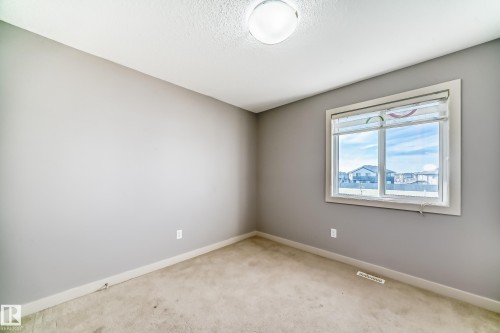 Neutral tone walls with a single window featuring a white frame - 1669 Hammond Crescent Nw, Edmonton, AB - Indoor Photo Showing Other Room
