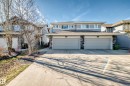 Two-story residence featuring a dual garage, stone accents, and a light-toned exterior with upper-level windows - 1669 Hammond Crescent Nw, Edmonton, AB  - Outdoor With Facade 