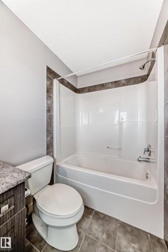 Bathroom featuring a white tub and shower combination with a curved shower rod - 1669 Hammond Crescent Nw, Edmonton, AB - Indoor Photo Showing Bathroom