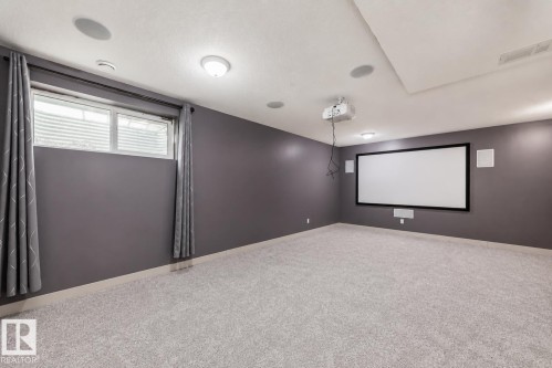 Dedicated media room featuring a large projection screen, mounted projector, and integrated ceiling speakers - 1669 Hammond Crescent Nw, Edmonton, AB - Indoor Photo Showing Other Room