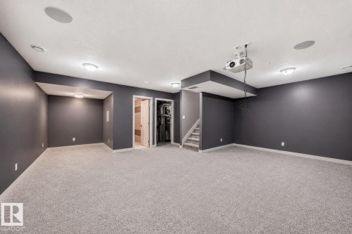 Spacious carpeted room with dark gray walls and a built-in ceiling projector - 1669 Hammond Crescent Nw, Edmonton, AB - Indoor