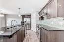 Kitchen featuring an expansive island with an undermount double sink, a gooseneck faucet, and pendant lighting - 1669 Hammond Crescent Nw, Edmonton, AB  - Indoor Photo Showing Kitchen With Double Sink With Upgraded Kitchen 