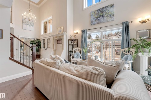 This spacious living area features high ceilings, large windows with views of the outdoors, and hardwood flooring - 6002 46 Avenue, Beaumont, AB - Indoor