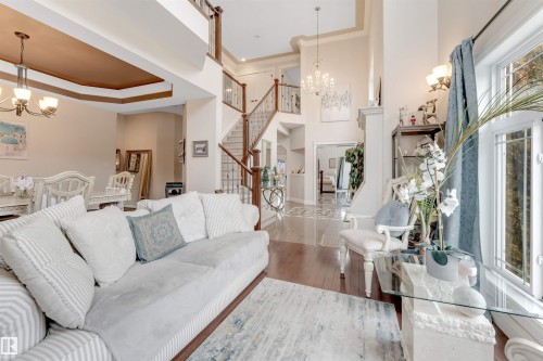 The spacious living area features high ceilings, hardwood flooring, and large windows providing natural light - 6002 46 Avenue, Beaumont, AB - Indoor Photo Showing Living Room