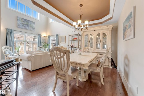 This inviting living space features hardwood floors, high ceilings, and large windows providing natural light - 6002 46 Avenue, Beaumont, AB - Indoor Photo Showing Dining Room