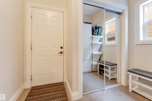 Entryway featuring a white paneled door, a mirrored closet with sliding doors, and windows with blinds - 6002 46 Avenue, Beaumont, AB - Indoor Photo Showing Other Room