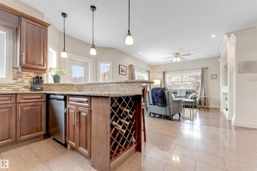 The kitchen features a breakfast bar with granite countertops and an integrated wine rack - 6002 46 Avenue, Beaumont, AB - Indoor Photo Showing Kitchen With Upgraded Kitchen