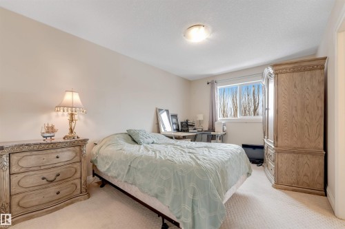 This room features neutral-toned walls, a window providing natural light, and carpeting throughout - 6002 46 Avenue, Beaumont, AB - Indoor Photo Showing Bedroom