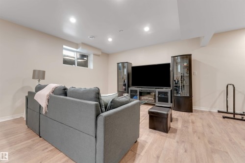 Inviting living space featuring light-colored flooring, recessed lighting, and a window - 6002 46 Avenue, Beaumont, AB - Indoor