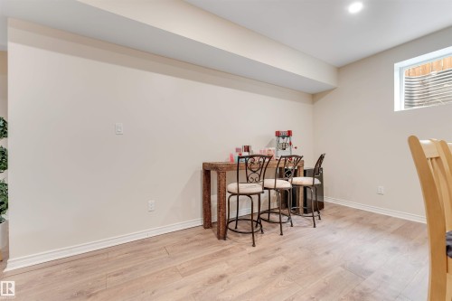 This open area features light-colored walls and wood-look flooring throughout - 6002 46 Avenue, Beaumont, AB - Indoor Photo Showing Other Room