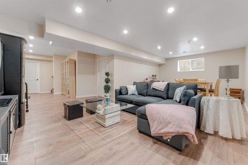 Spacious living area featuring light-toned flooring, recessed lighting, and a window providing natural light - 6002 46 Avenue, Beaumont, AB - Indoor