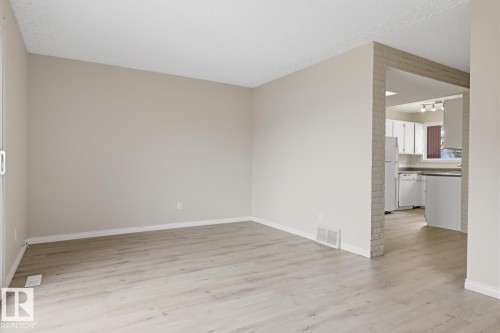 Open concept living space featuring light wood-finish flooring, neutral wall paint, and white baseboards - 10640 Beaumaris Road, Edmonton, AB - Indoor Photo Showing Other Room