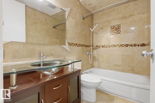 Bathroom featuring a dark wood-finish vanity with a glass countertop and vessel sink - 10640 Beaumaris Road, Edmonton, AB - Indoor Photo Showing Bathroom