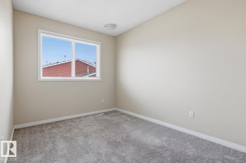 Neutral paint palette with a single window featuring horizontal blinds - 10640 Beaumaris Road, Edmonton, AB - Indoor Photo Showing Other Room