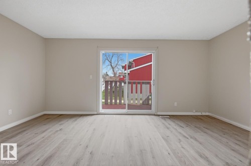 Bright interior space featuring light-toned walls, wood-finish flooring, and white baseboards - 10640 Beaumaris Road, Edmonton, AB - Indoor Photo Showing Other Room