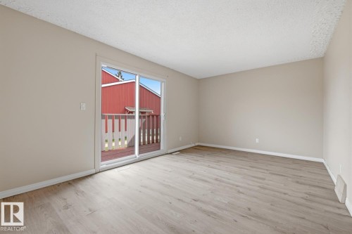 Spacious room featuring wood-finish flooring and neutral wall tones - 10640 Beaumaris Road, Edmonton, AB - Indoor Photo Showing Other Room