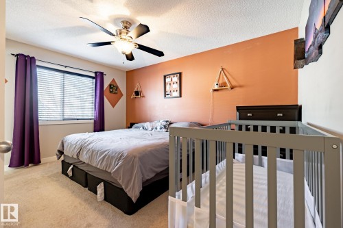 Carpeted room featuring a ceiling fan with light fixture, a window with horizontal blinds, and a built-in wall shelf - 40 12004 22 Avenue, Edmonton, AB - Indoor Photo Showing Bedroom