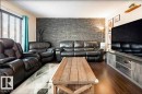 Living area featuring a prominent dark stacked stone accent wall - 40 12004 22 Avenue, Edmonton, AB  - Indoor Photo Showing Living Room 