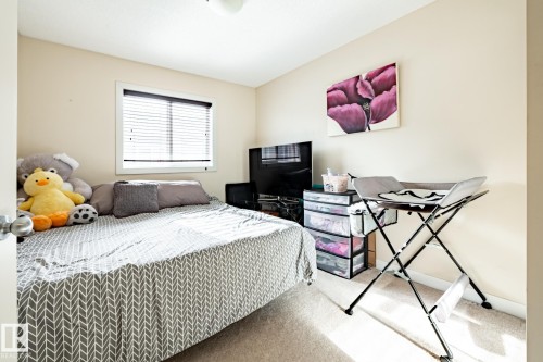 Bedroom featuring neutral wall paint, carpet flooring, a window with blinds, and an overhead light fixture - 40 12004 22 Avenue, Edmonton, AB - Indoor Photo Showing Bedroom