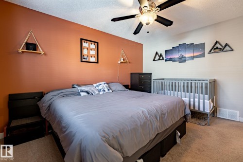 Bedroom featuring carpet flooring, a ceiling fan with light, and an accent wall - 40 12004 22 Avenue, Edmonton, AB - Indoor Photo Showing Bedroom