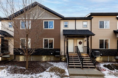 The property features a multi-level facade with horizontal siding and a stone-look accent on the lower level - 40 12004 22 Avenue, Edmonton, AB - Outdoor