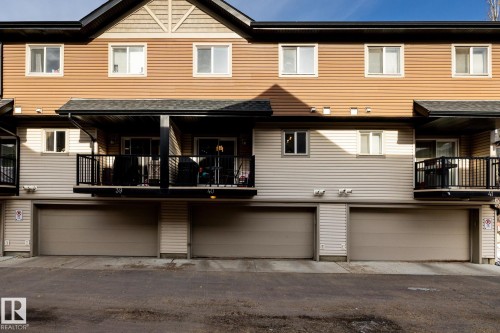 The property features a multi-level design with brown and beige siding, complete with balconies and integrated garages - 40 12004 22 Avenue, Edmonton, AB - Outdoor With Exterior