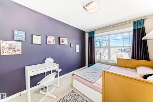 Bright room with a large window and a ceiling-mounted light fixture - 5020 Orchards Gate, Edmonton, AB - Indoor Photo Showing Bedroom
