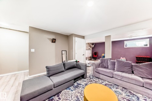 Finished basement space featuring light wood-finish flooring, recessed lighting, and a white interior door - 5020 Orchards Gate, Edmonton, AB - Indoor Photo Showing Living Room