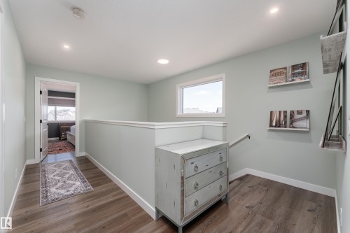 Upper-level hallway featuring wood-finish flooring, recessed lighting, and a white framed window - 1450 Darby Green, Edmonton, AB - Indoor Photo Showing Other Room