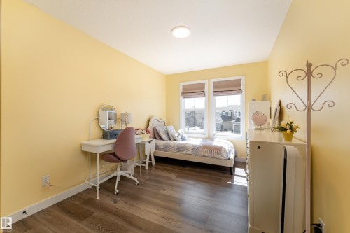 Room featuring wood-finish flooring, light yellow walls, and white trim - 1450 Darby Green, Edmonton, AB - Indoor Photo Showing Bedroom