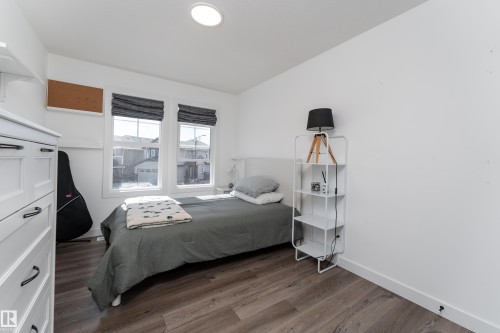 Bright interior space featuring wood-finish flooring, white painted walls, and a recessed ceiling light - 1450 Darby Green, Edmonton, AB - Indoor Photo Showing Bedroom