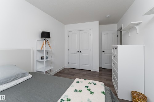 Room featuring light-colored wood-finish flooring, white walls, and bright white trim - 1450 Darby Green, Edmonton, AB - Indoor Photo Showing Bedroom