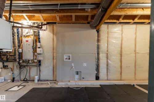 Unfinished basement area featuring exposed wood joists, visible insulation, and utility access - 1450 Darby Green, Edmonton, AB - Indoor Photo Showing Basement