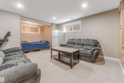 Carpeted living space with recessed lighting and a built-in wood-finish cabinet - 3236 26 Avenue, Edmonton, AB - Indoor Photo Showing Basement