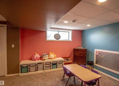 Finished basement space featuring carpeted flooring, a drop ceiling with recessed lighting, and a window for natural light - 5121 52 Ave, St. Paul Town, AB - Indoor