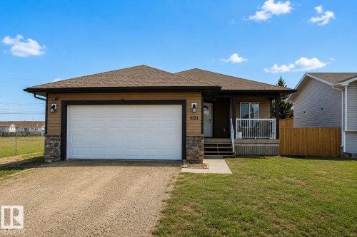 Ranch-style exterior with tan siding and dark trim - 5121 52 Ave, St. Paul Town, AB - Outdoor