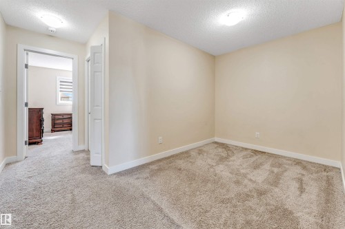 Carpeted room featuring a neutral color palette, recessed ceiling light fixtures, and white trim molding - 1715 27 Street, Edmonton, AB - Indoor Photo Showing Other Room