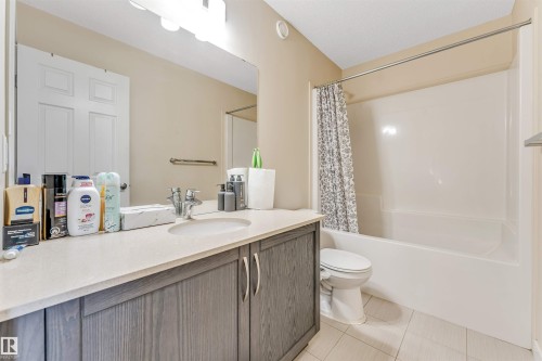 Bathroom featuring a single vanity with a light gray countertop, dark wood-finish cabinetry, an undermount sink, and a chrome faucet - 1715 27 Street, Edmonton, AB - Indoor Photo Showing Bathroom