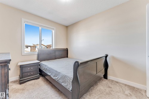 Neutral-toned bedroom featuring a large window, light beige walls, and carpet flooring - 1715 27 Street, Edmonton, AB - Indoor Photo Showing Bedroom