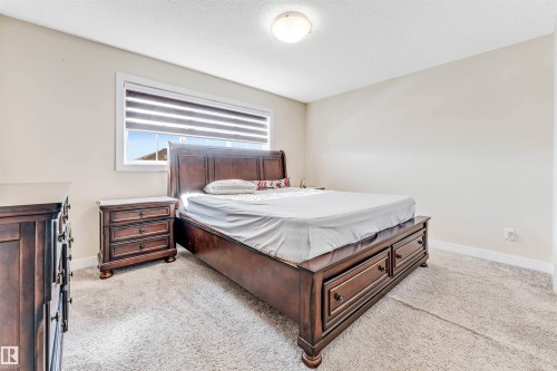 Bedroom featuring light neutral wall paint, white trim, and light-toned carpet - 1715 27 Street, Edmonton, AB - Indoor Photo Showing Bedroom