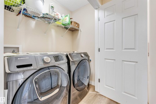 Dedicated utility space featuring light-colored walls and wood-finish flooring - 1715 27 Street, Edmonton, AB - Indoor Photo Showing Laundry Room