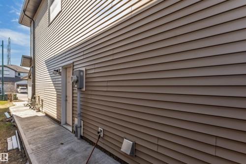 Horizontal siding exterior with a concrete pathway and side entrance - 1715 27 Street, Edmonton, AB - Outdoor