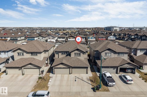 Two-story residential property featuring a neutral exterior, a double attached garage, and a peaked roofline - 1715 27 Street, Edmonton, AB - Outdoor